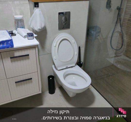 אסלה עם מכסה פתוח בחדר אמבטיה